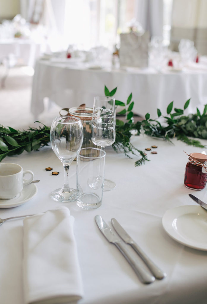 Decorated table with glasses, silverware, plates, and decor